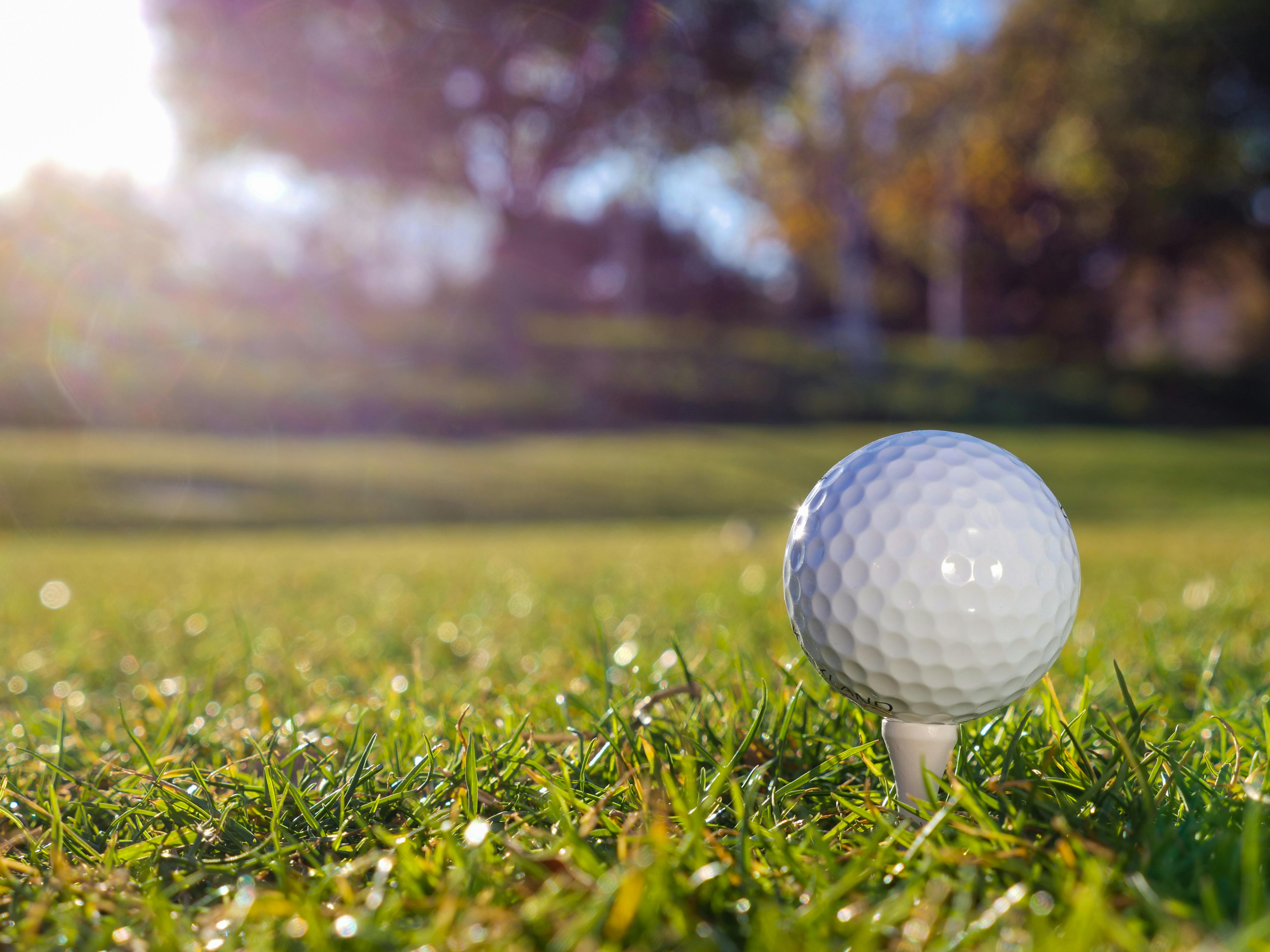 golf ball on tee on golf course green